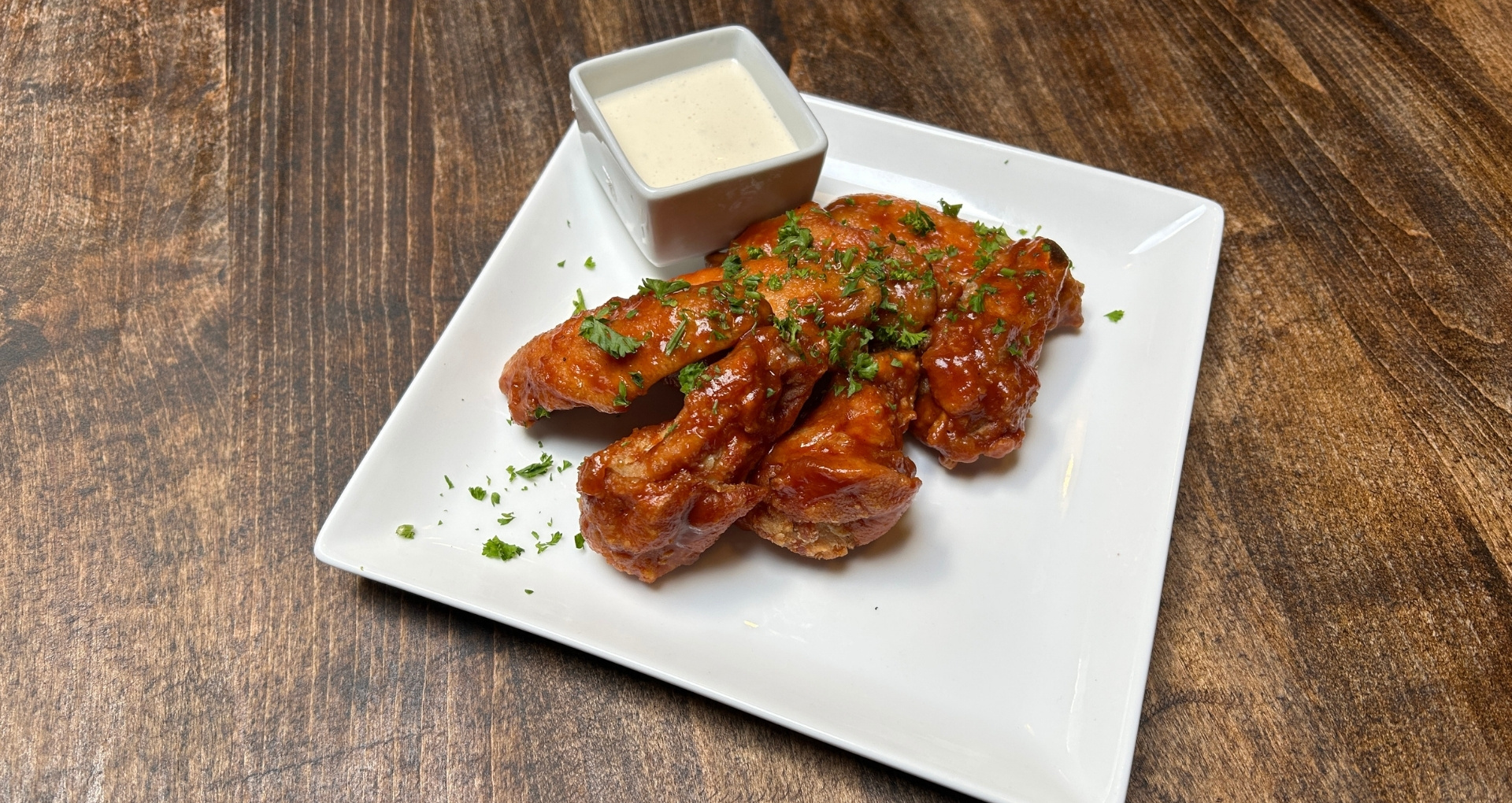 Eatery Wings with sauce and a side of house dip